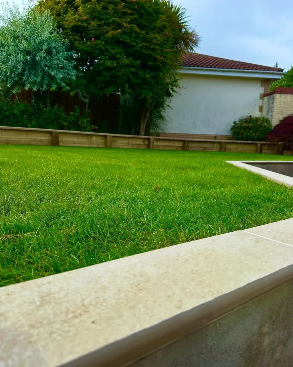 Full garden renovation - levelling, sleeper beds, fresh turf, porcelain copings and new steps