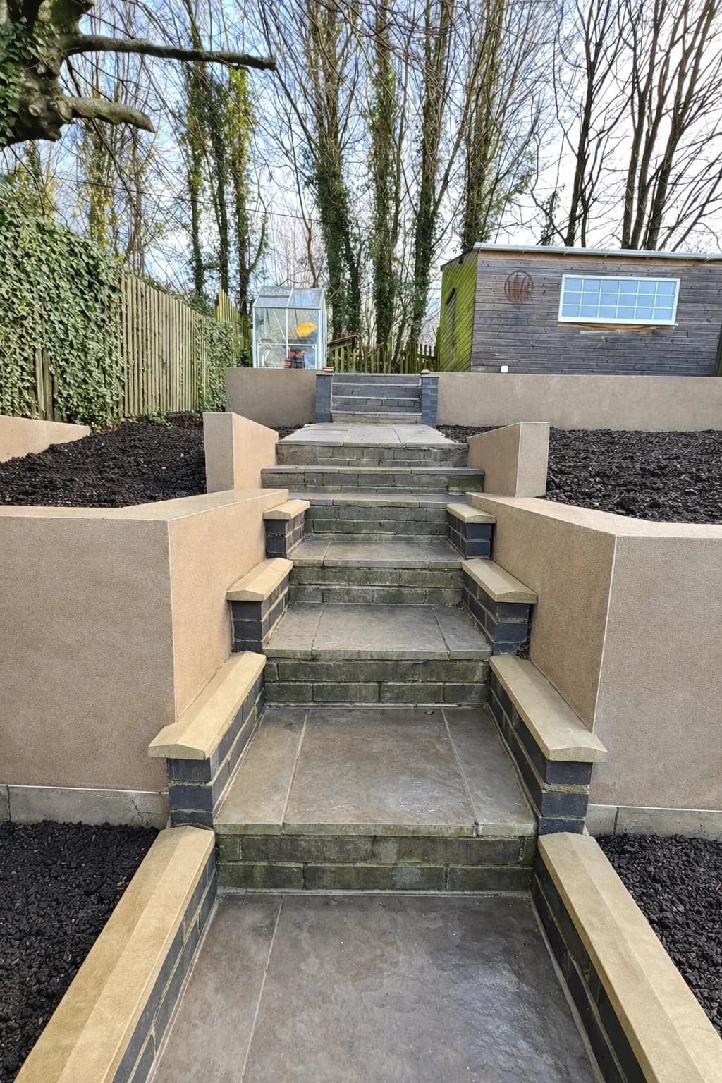 Close-up of smooth rendered retaining walls constructed from blockwork to form strong, tidy garden levels.