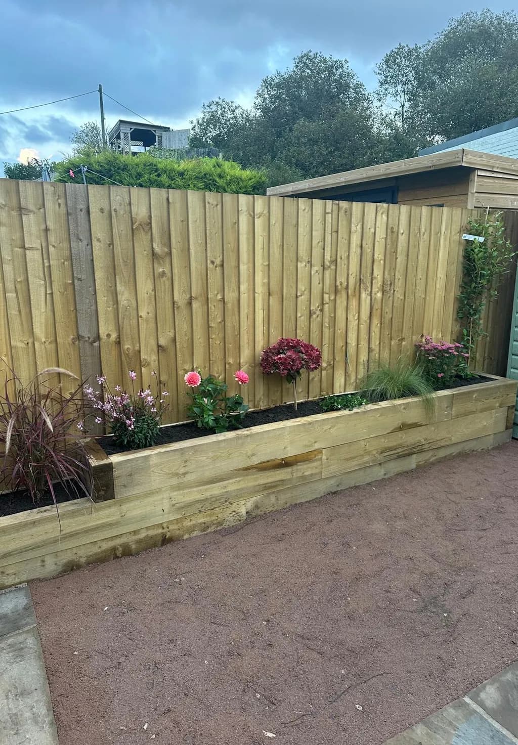 Close-up view of raised sleeper beds installed ahead of Indian Sandstone patio.