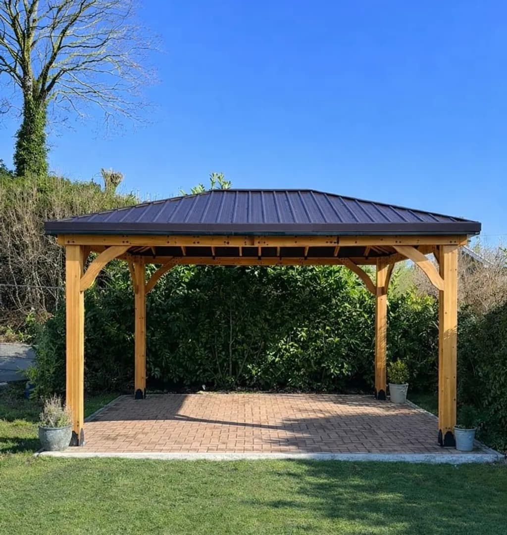 Cedar-wood gazebo built over a block-paving patio.