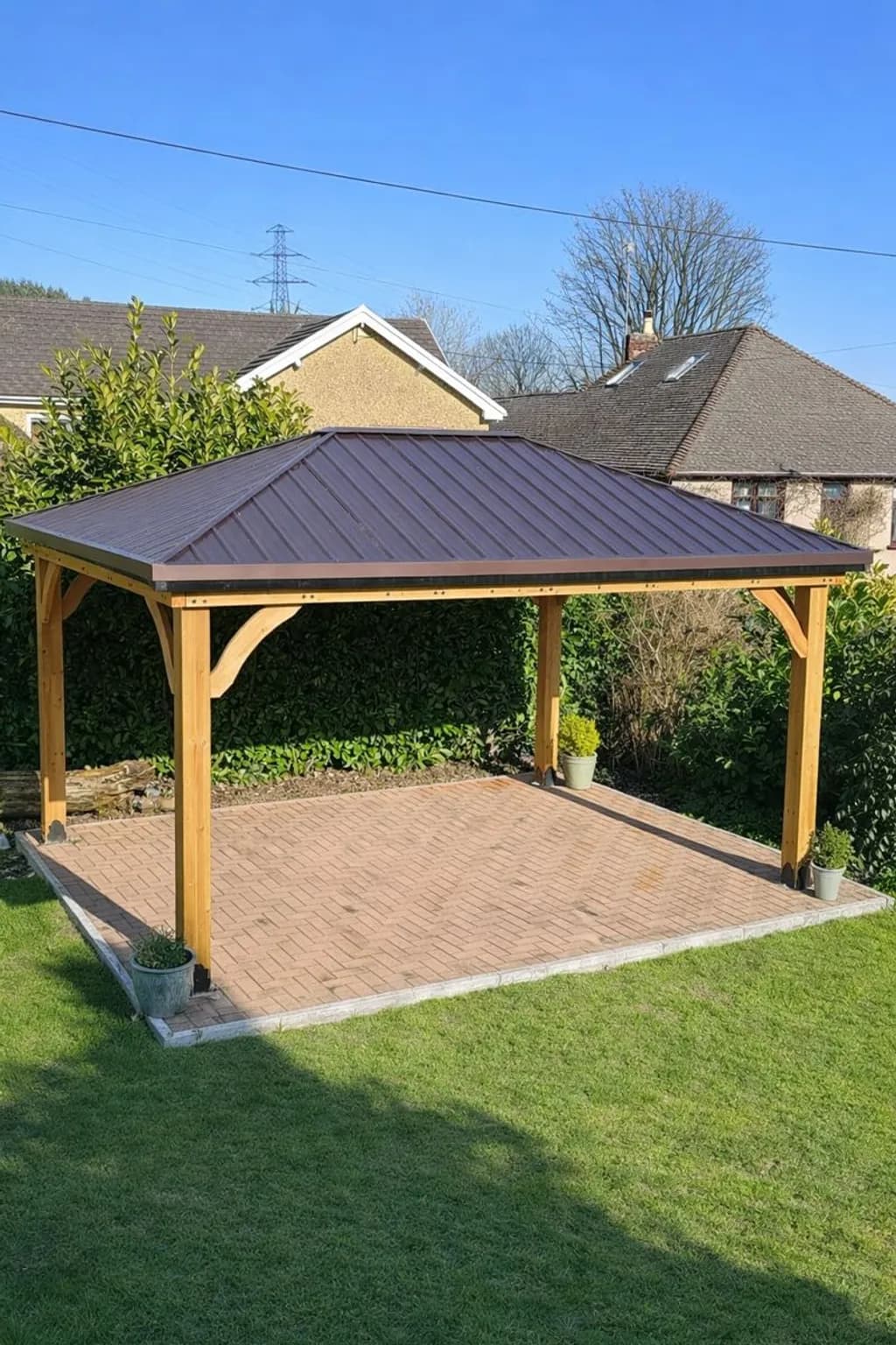 Block-paved patio area sheltered by a modern cedar gazebo structure.