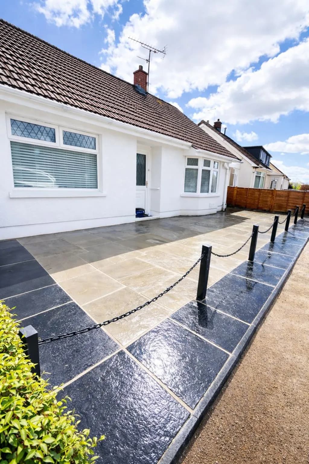 Front garden in Ebbw Vale transformed into a full grey Indian sandstone patio with black limestone border and decorative bollards with barrier chains.