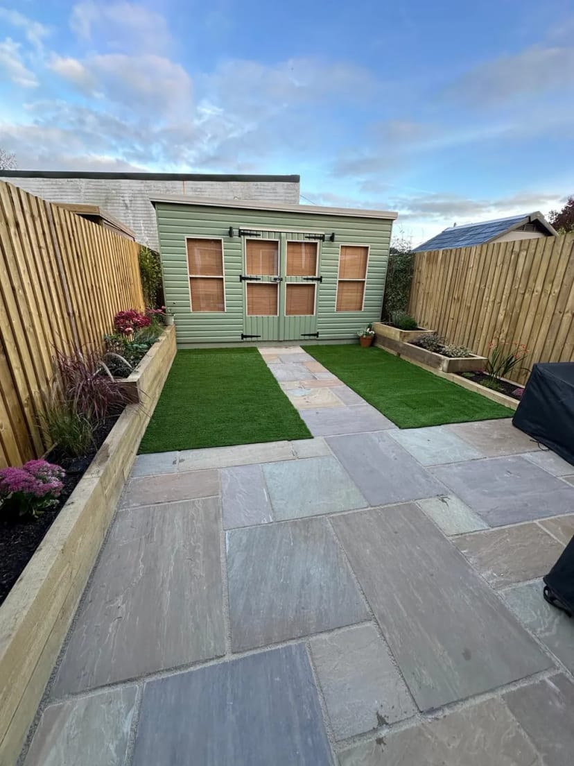 Sandstone patio with raised planters, astroturf, fencing & summerhouse