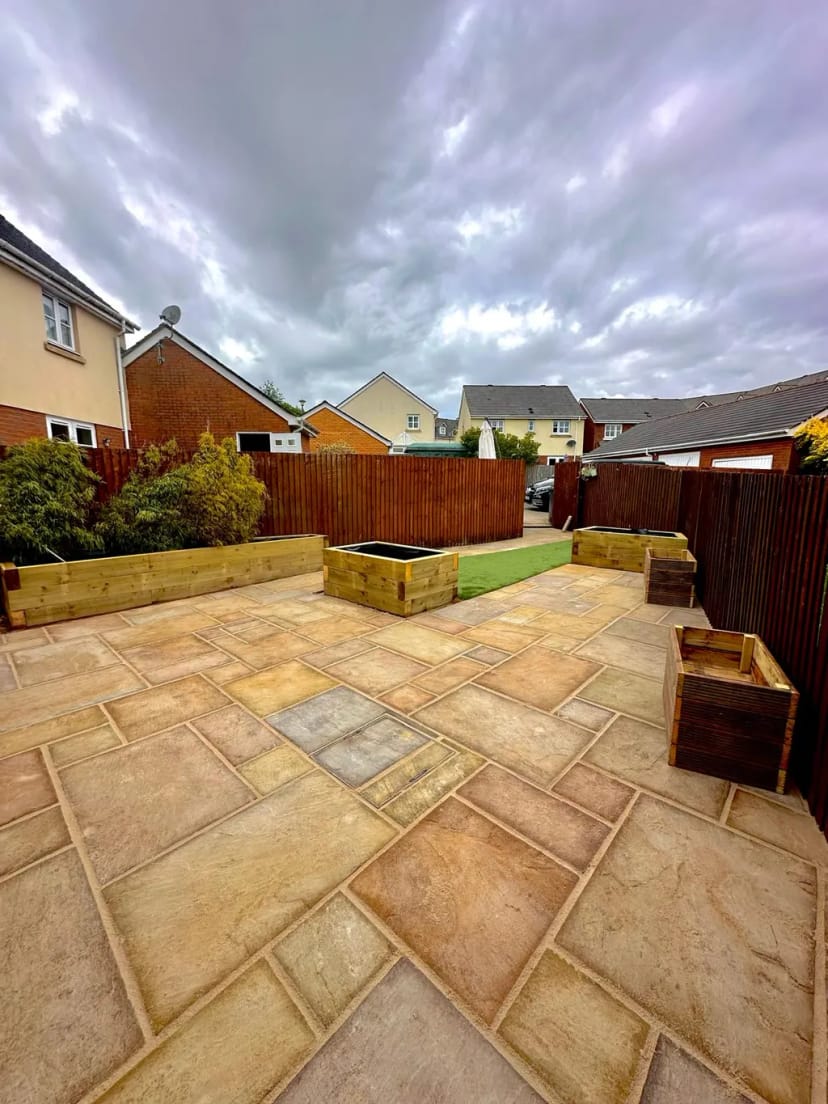 Sandstone patio with raised planters and astroturf