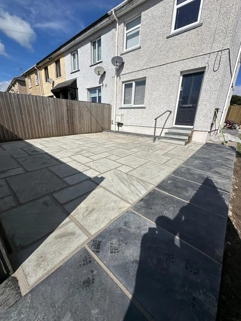 Sandstone patio with black limestone pathway and capping stones
